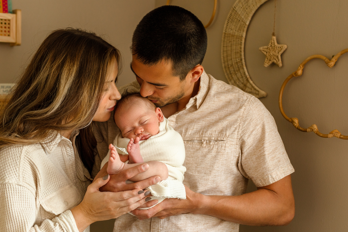 mom and dad kissing Ezra's head