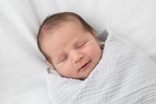 baby boy laying in a white swaddle