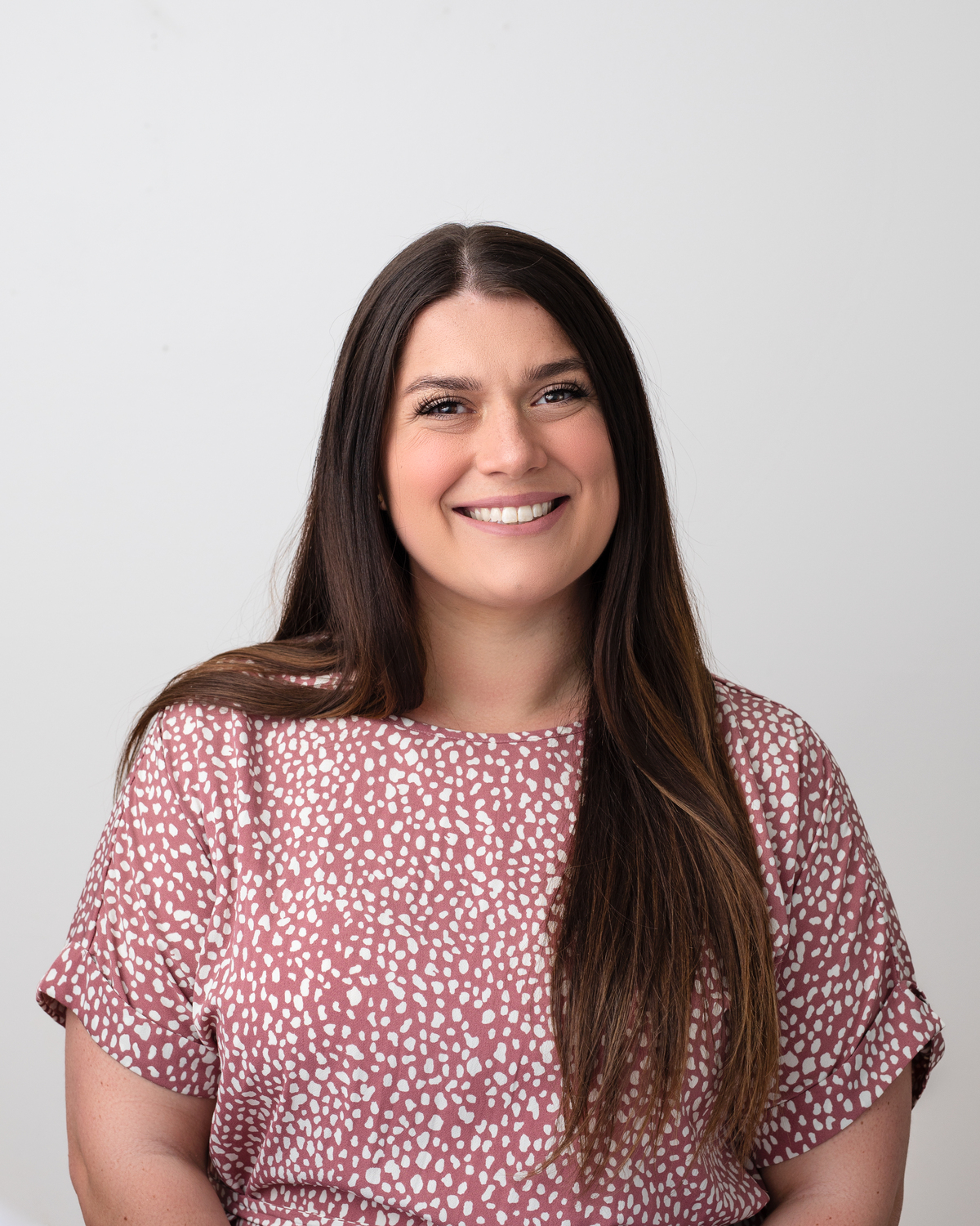 brunette lady in front of white backdrop