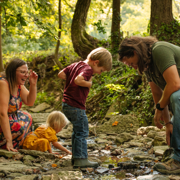 family playing in the creek